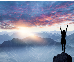 Women on Mountain in sunset raising her arms